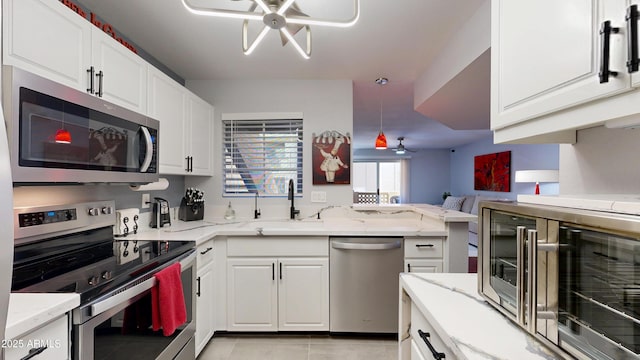 kitchen featuring appliances with stainless steel finishes, white cabinets, and a sink