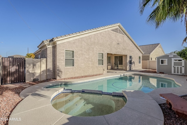 view of pool featuring an in ground hot tub, a patio, and a shed