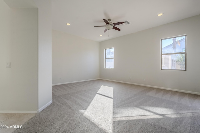 carpeted spare room featuring ceiling fan