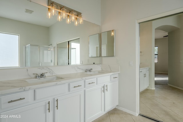 bathroom featuring tile patterned flooring, vanity, and a shower with door