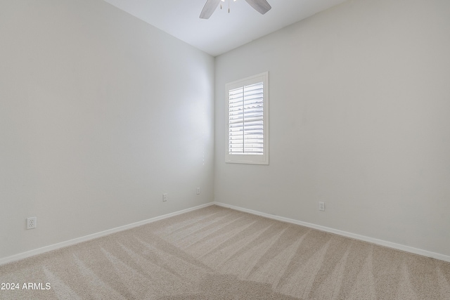 spare room featuring light carpet and ceiling fan