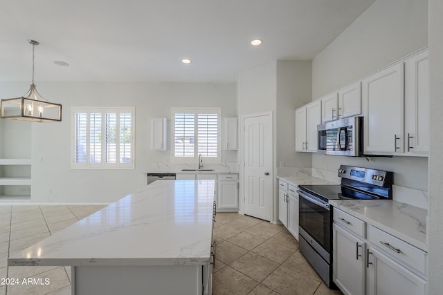 kitchen with stainless steel appliances, decorative light fixtures, an inviting chandelier, a center island, and white cabinetry