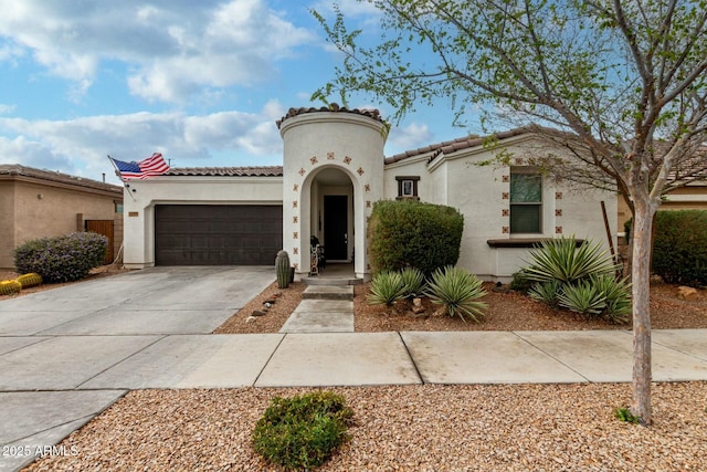 mediterranean / spanish-style home featuring stucco siding, a tiled roof, concrete driveway, and a garage