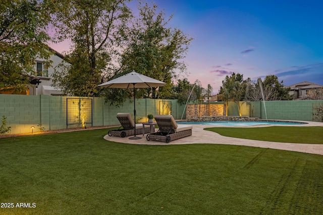 yard at dusk featuring pool water feature, a fenced in pool, and a patio area