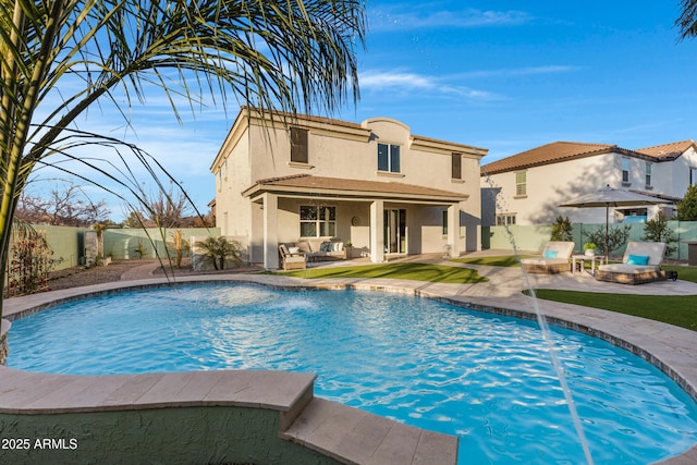 back of house with pool water feature, an outdoor living space with a fire pit, and a patio area