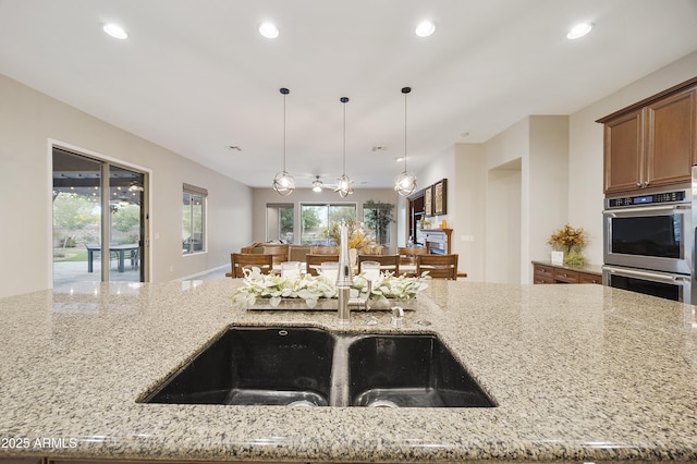 2727 S Balboa Dr, Gilbert, AZ 85295 - kitchen featuring a sink, double oven, light stone counters, recessed lighting, and pendant lighting