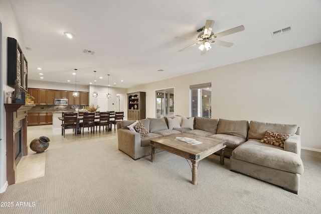 2727 S Balboa Dr, Gilbert, AZ 85295 - living room featuring a ceiling fan, recessed lighting, light colored carpet, a fireplace, and baseboards