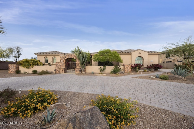 2727 S Balboa Dr, Gilbert, AZ 85295 - mediterranean / spanish home featuring stucco siding, a gate, a tile roof, and stone siding