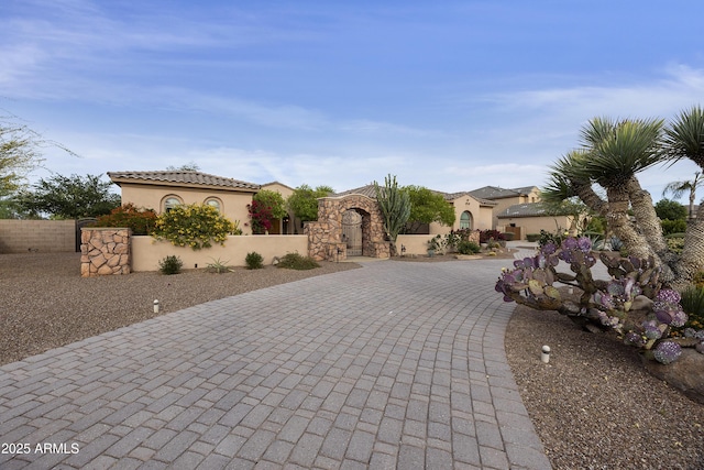 2727 S Balboa Dr, Gilbert, AZ 85295 - mediterranean / spanish house featuring curved driveway, fence, stucco siding, and a gate