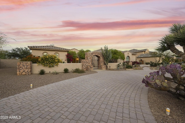 2727 S Balboa Dr, Gilbert, AZ 85295 - patio terrace at dusk with curved driveway, fence, and a gate