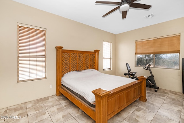 bedroom with ceiling fan, multiple windows, and visible vents