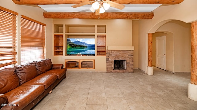 tiled living room featuring baseboards, a ceiling fan, built in shelves, a fireplace, and beam ceiling