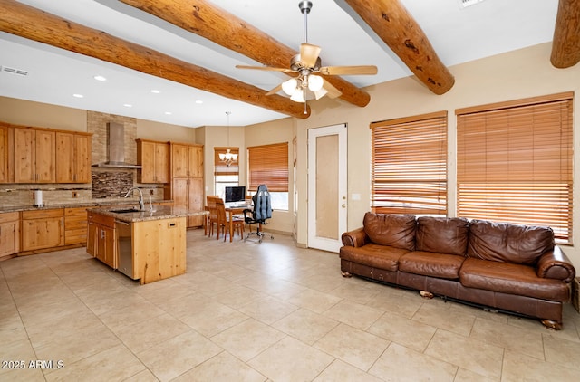 kitchen with wall chimney exhaust hood, open floor plan, backsplash, beamed ceiling, and a sink