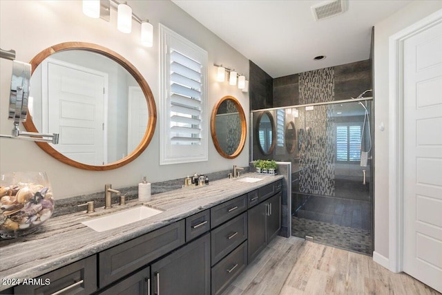 bathroom with vanity, wood-type flooring, a shower with door, and plenty of natural light