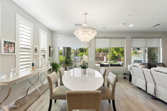 dining space featuring an inviting chandelier and light hardwood / wood-style flooring