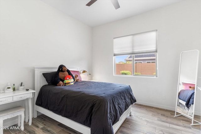 bedroom featuring wood finished floors, a ceiling fan, and baseboards