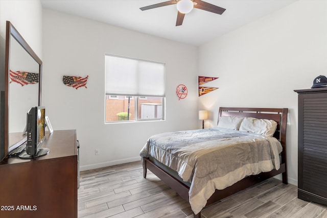 bedroom featuring wood finish floors, a ceiling fan, and baseboards