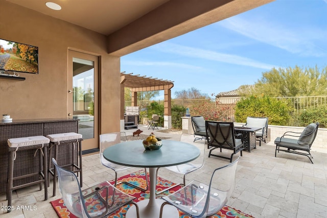 view of patio featuring outdoor dining space, fence, and a pergola