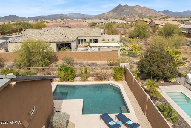 view of swimming pool featuring a fenced backyard, a mountain view, and a fenced in pool