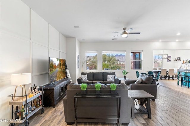 living room with a ceiling fan, light wood-type flooring, and recessed lighting