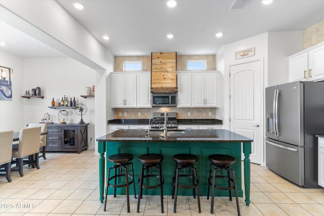 kitchen featuring light tile patterned flooring, stainless steel appliances, a sink, visible vents, and white cabinetry