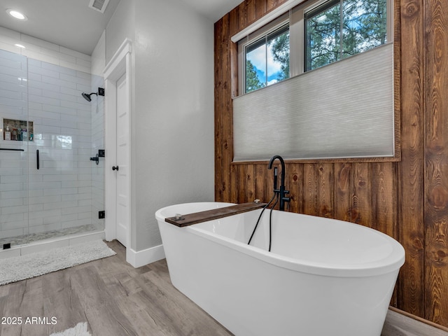 956 S Torrey Pines Dr, Williams, AZ 86046 - bathroom featuring a shower stall, a freestanding tub, wood finished floors, wooden walls, and recessed lighting