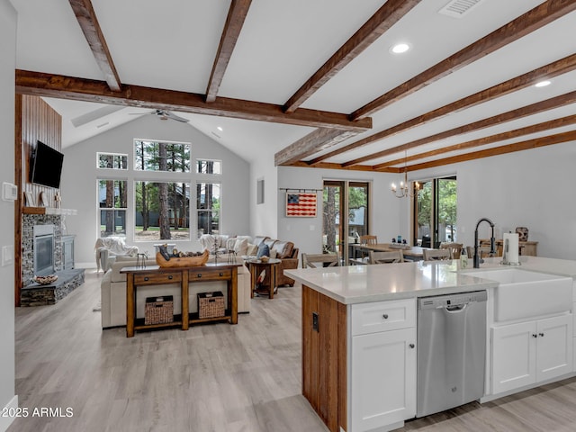 956 S Torrey Pines Dr, Williams, AZ 86046 - kitchen with stainless steel dishwasher, open floor plan, a glass covered fireplace, light countertops, and white cabinets