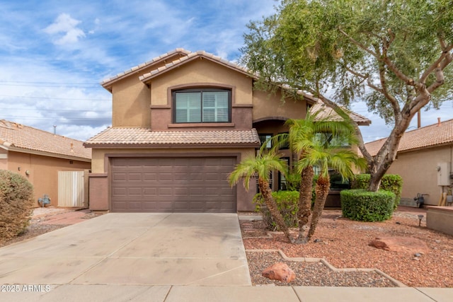 view of front of property with stucco siding, concrete driveway, an attached garage, and a tile roof