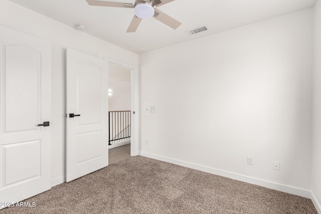 unfurnished bedroom featuring baseboards, visible vents, carpet floors, and ceiling fan