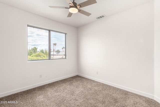 empty room with visible vents, carpet flooring, a ceiling fan, and baseboards