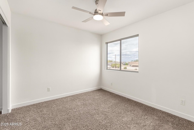 carpeted spare room with baseboards and ceiling fan