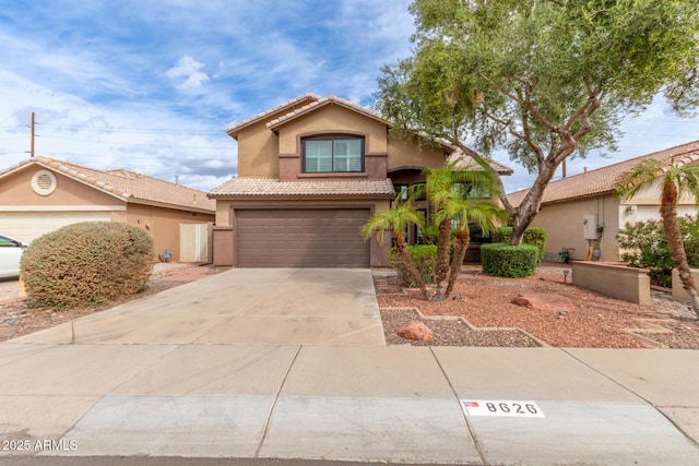 view of front facade featuring stucco siding, a garage, concrete driveway, and a tiled roof