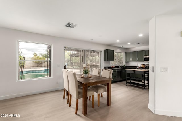 dining area featuring visible vents, a healthy amount of sunlight, and baseboards