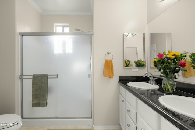 bathroom featuring toilet, a shower with shower door, crown molding, and vanity