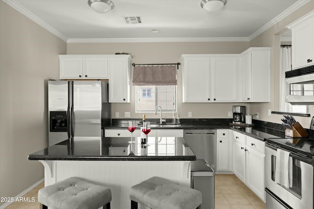 kitchen featuring stainless steel appliances, white cabinetry, light tile patterned floors, and sink