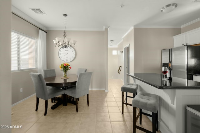 dining area featuring an inviting chandelier, ornamental molding, and light tile patterned floors