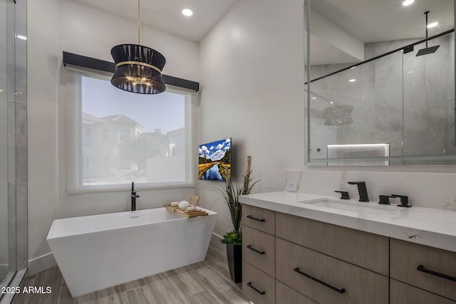 bathroom featuring an inviting chandelier, vanity, and shower with separate bathtub