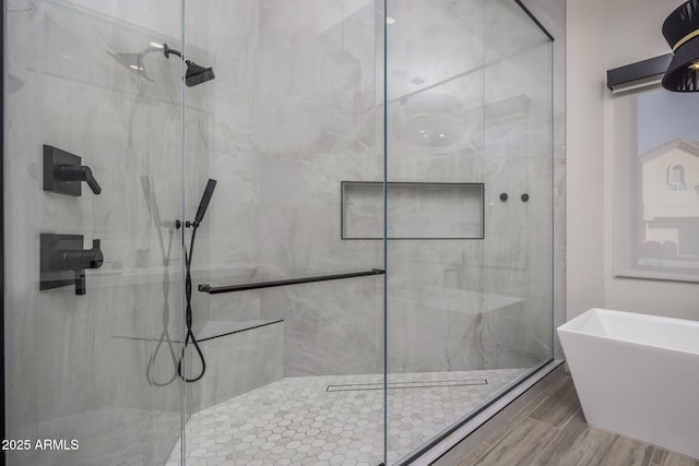 bathroom featuring shower with separate bathtub and wood-type flooring