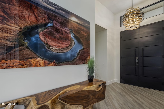 foyer with light hardwood / wood-style flooring and a notable chandelier