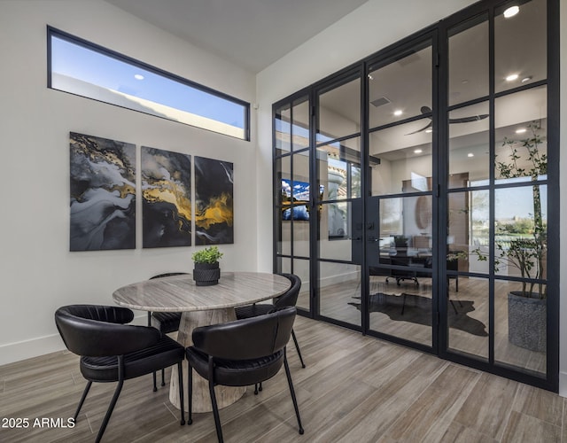 dining space with hardwood / wood-style flooring, plenty of natural light, and french doors