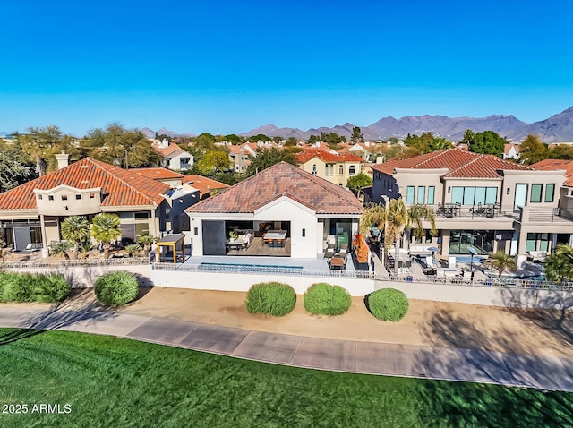 back of house with a patio, a mountain view, and a lawn