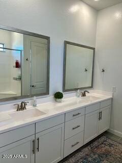 bathroom with double vanity, a sink, and baseboards