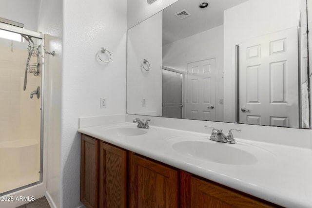 bathroom with vanity and a shower with shower door