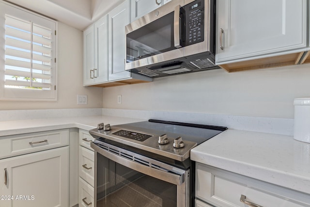 kitchen with appliances with stainless steel finishes and white cabinets