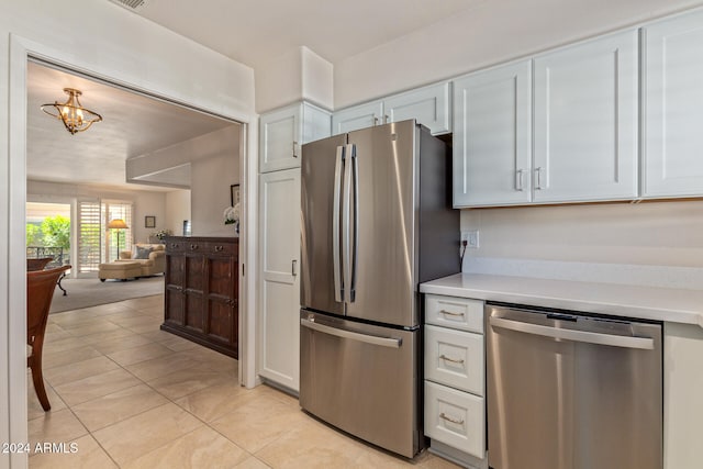 kitchen featuring appliances with stainless steel finishes, white cabinets, and light tile patterned floors