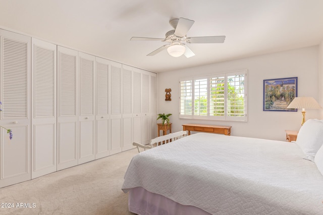 bedroom featuring a closet, light carpet, and ceiling fan