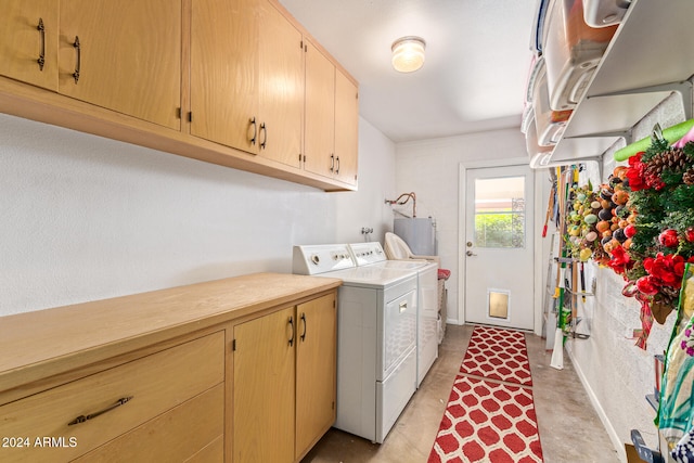 washroom with electric water heater, cabinets, and washing machine and clothes dryer