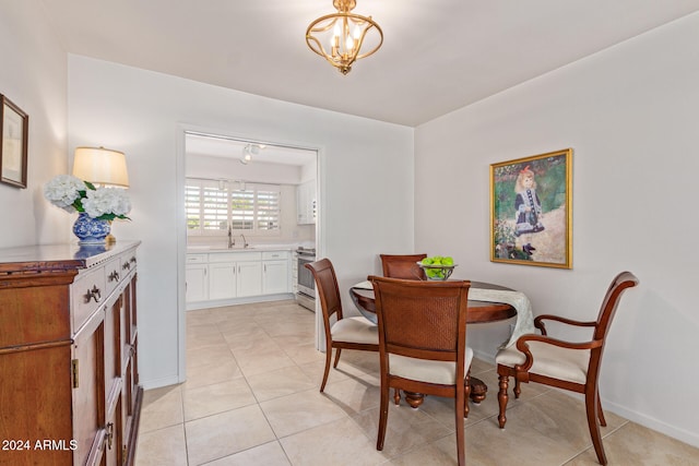 tiled dining space featuring sink and a chandelier