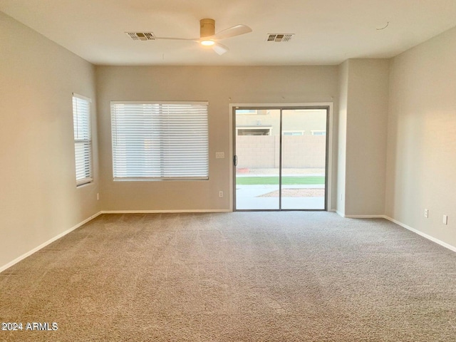 spare room with ceiling fan, a healthy amount of sunlight, and carpet