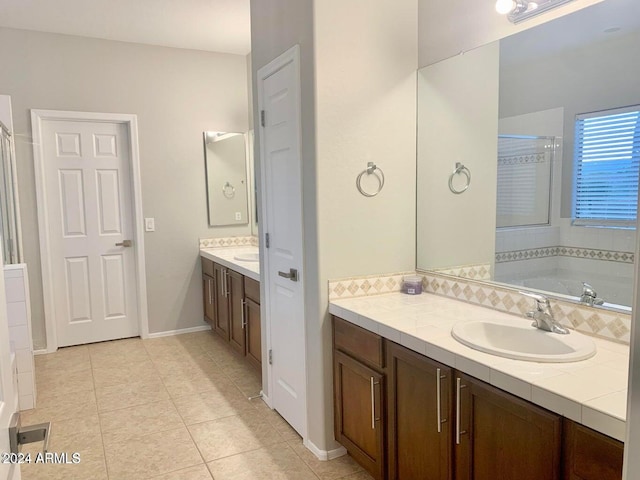 bathroom with vanity, a bath, and tile patterned flooring